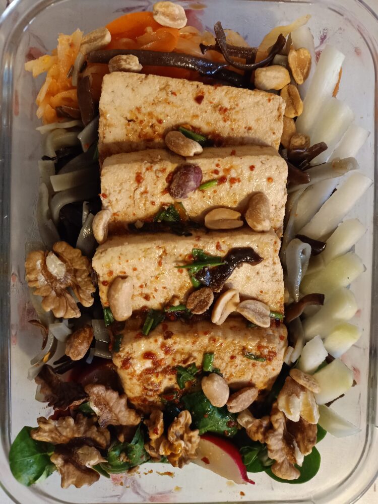 Makaron ryżowy z grzybami mun i tofu. w towarzystwie kalarepy, rukoli, kimczi, orzeszków ziemnych i włoskich